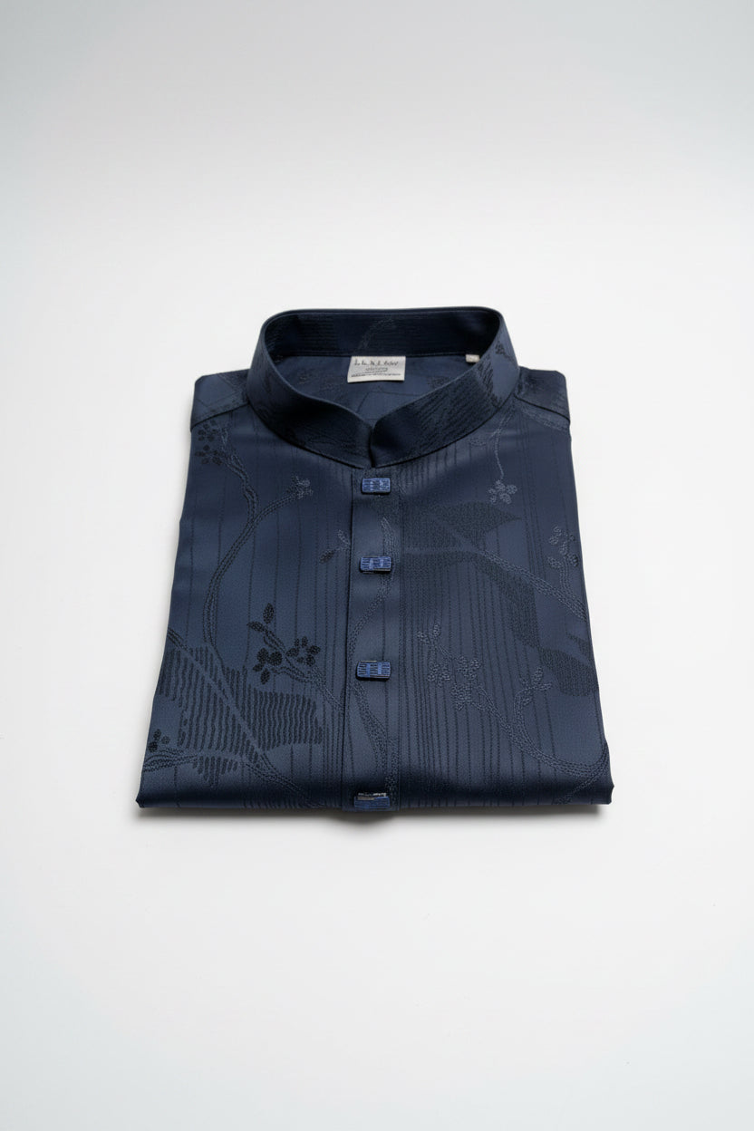 Folded navy blue shirt with floral pattern on a white background